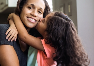 Mom hugging young daughter 